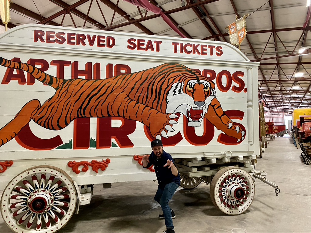 Man posing in front of tiger painted trailer