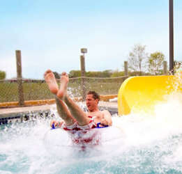 man splashing into water at end of water slide