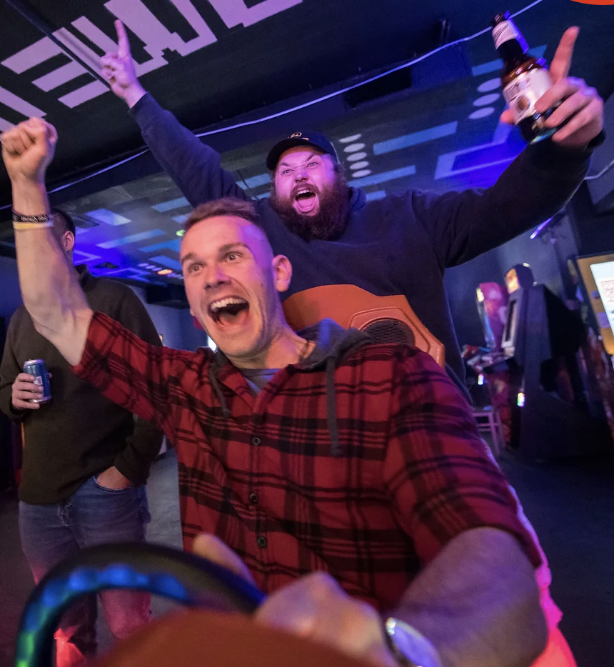 men celebrating a win at the gaming arcade