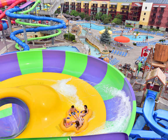 aerial view of four kids riding a tube down a water slide