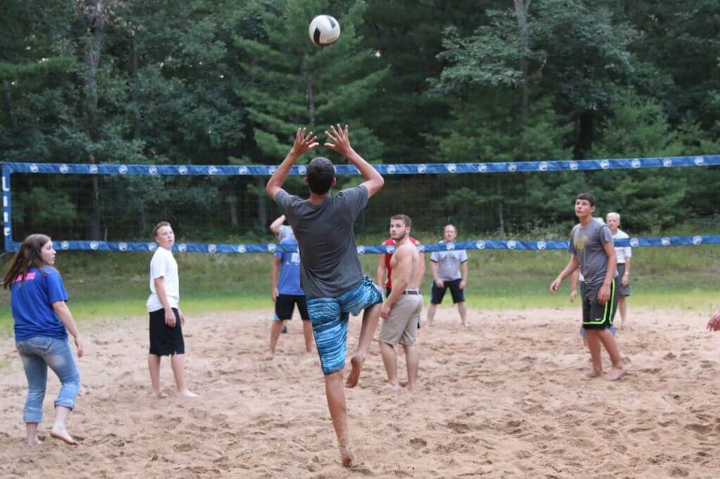 young adults playing sand volleyball