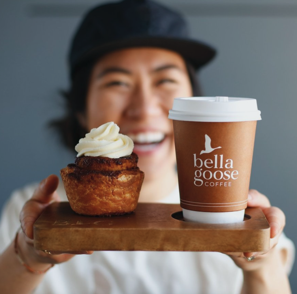 woman serving homemade cinnamon roll and Bella Goose Coffee