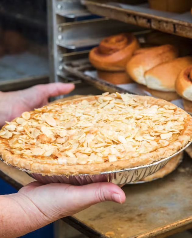 woman's hands holding a large almond pie
