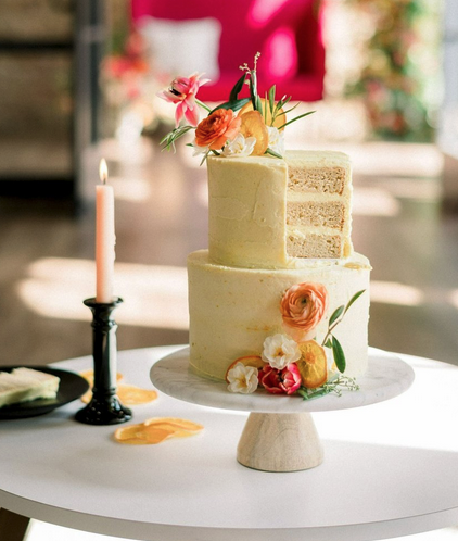 elegant two-tier vanilla cake with peach, yellow and white flowers