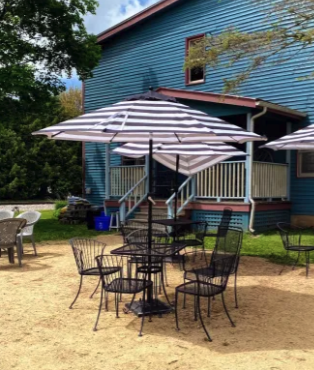 patio furniture and umbrellas outside a blue building