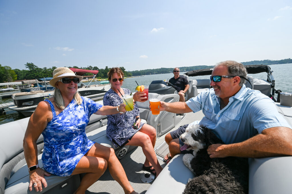 friends and dog sitting on a boat on the lake